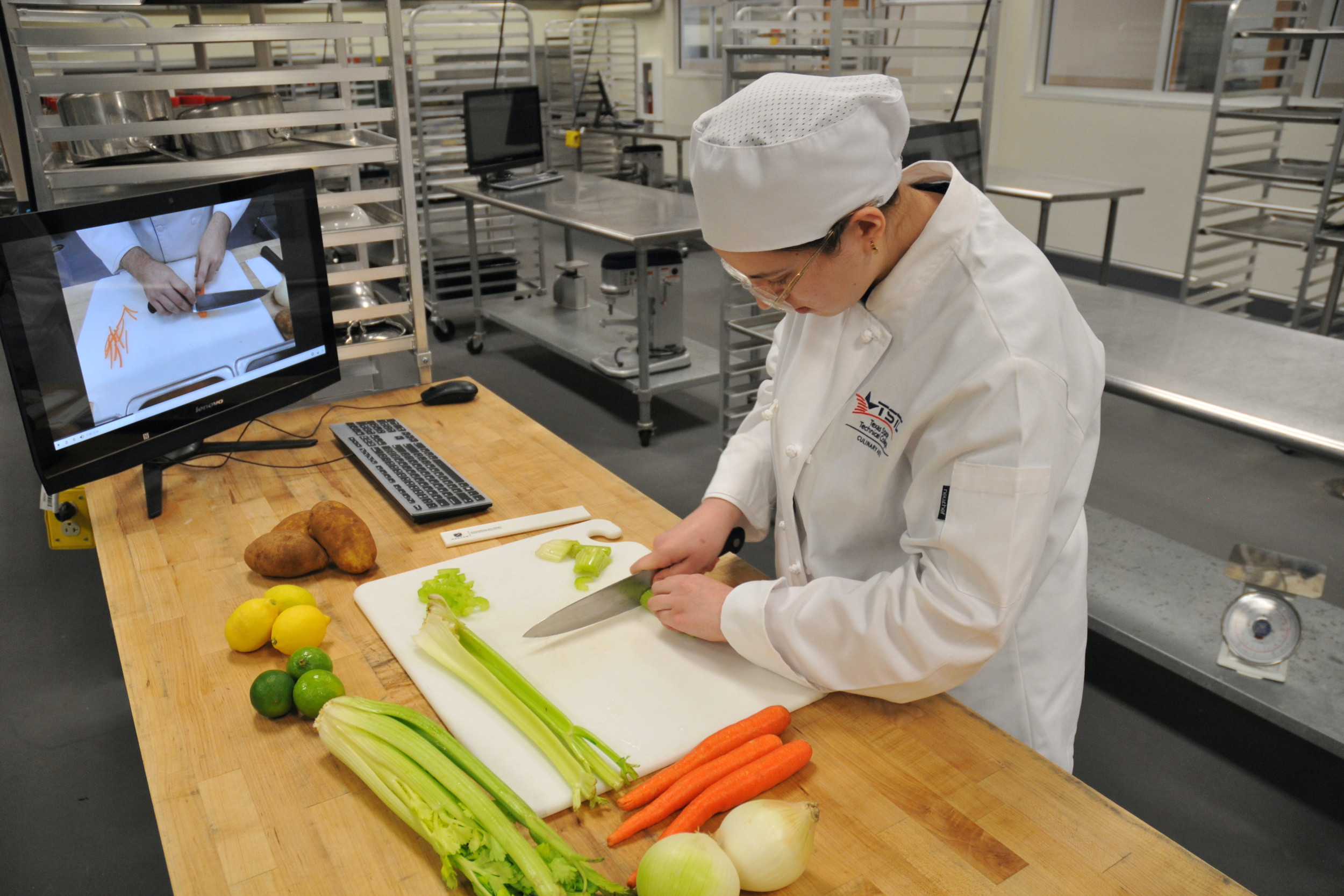 tstc culinary student following instructional video on vegetable cutting