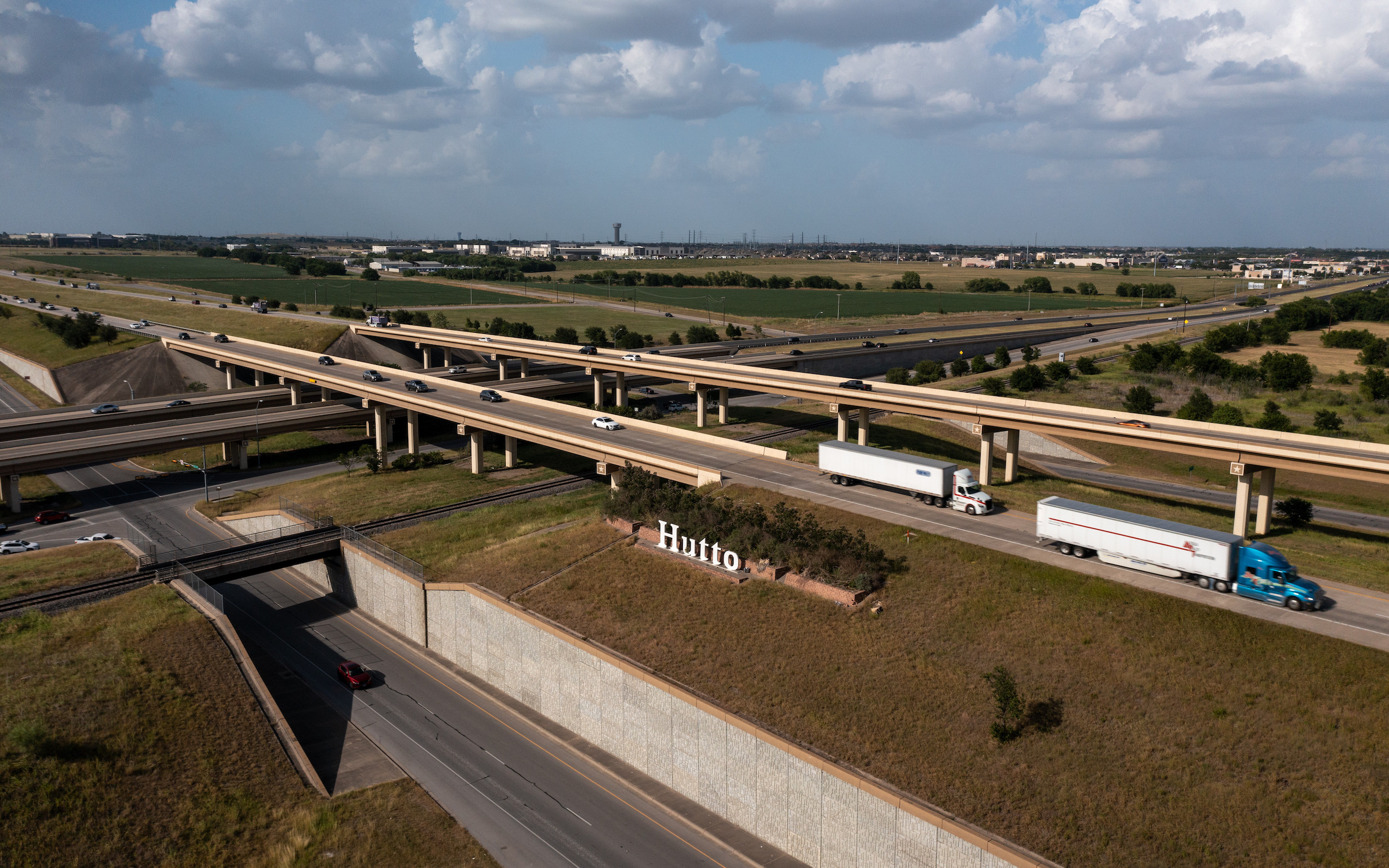 photo of vehicles on a highway with the hutto sign in the foreground