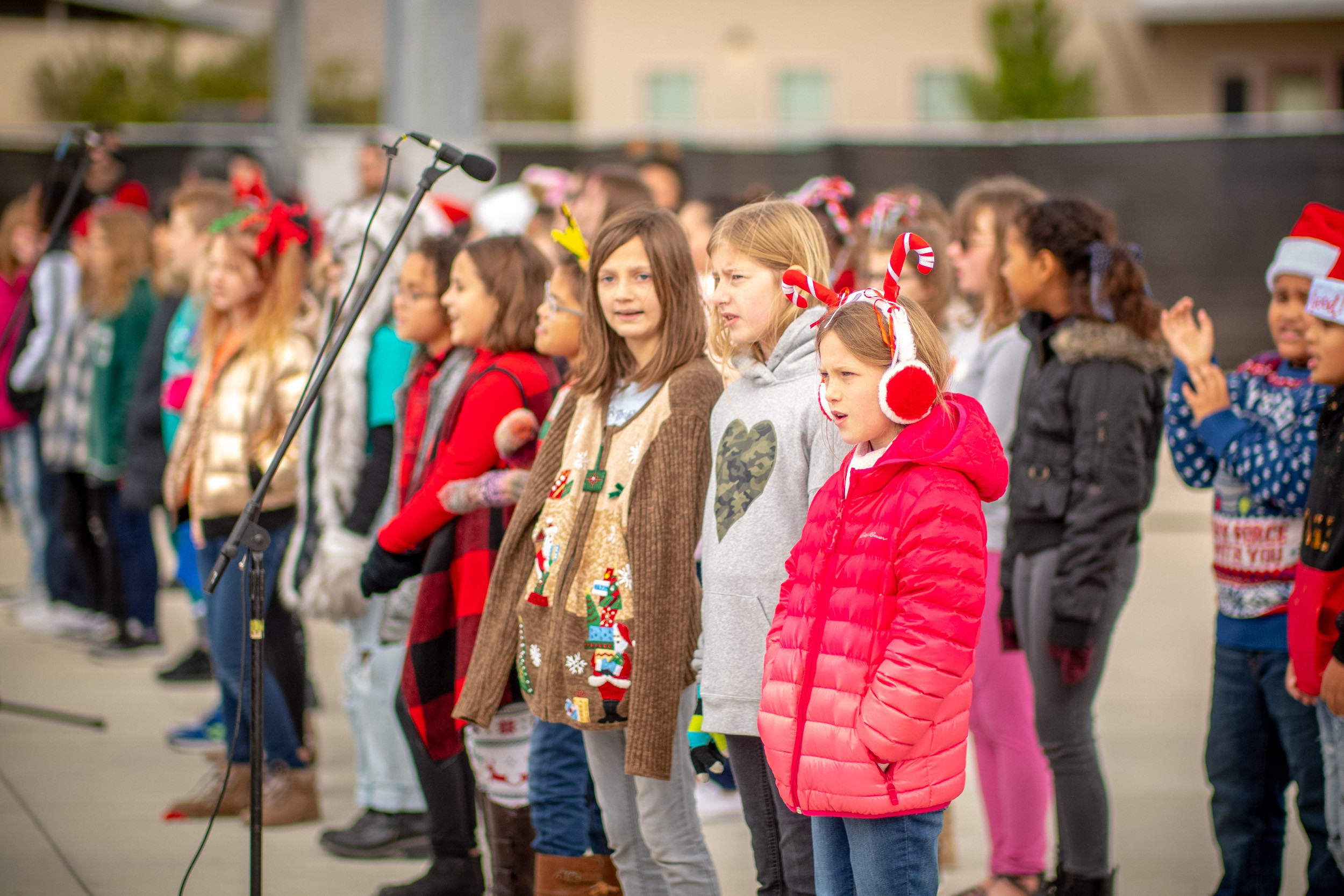 Photo of children wearing coats and Christmas attire singing at a Hutto community event.