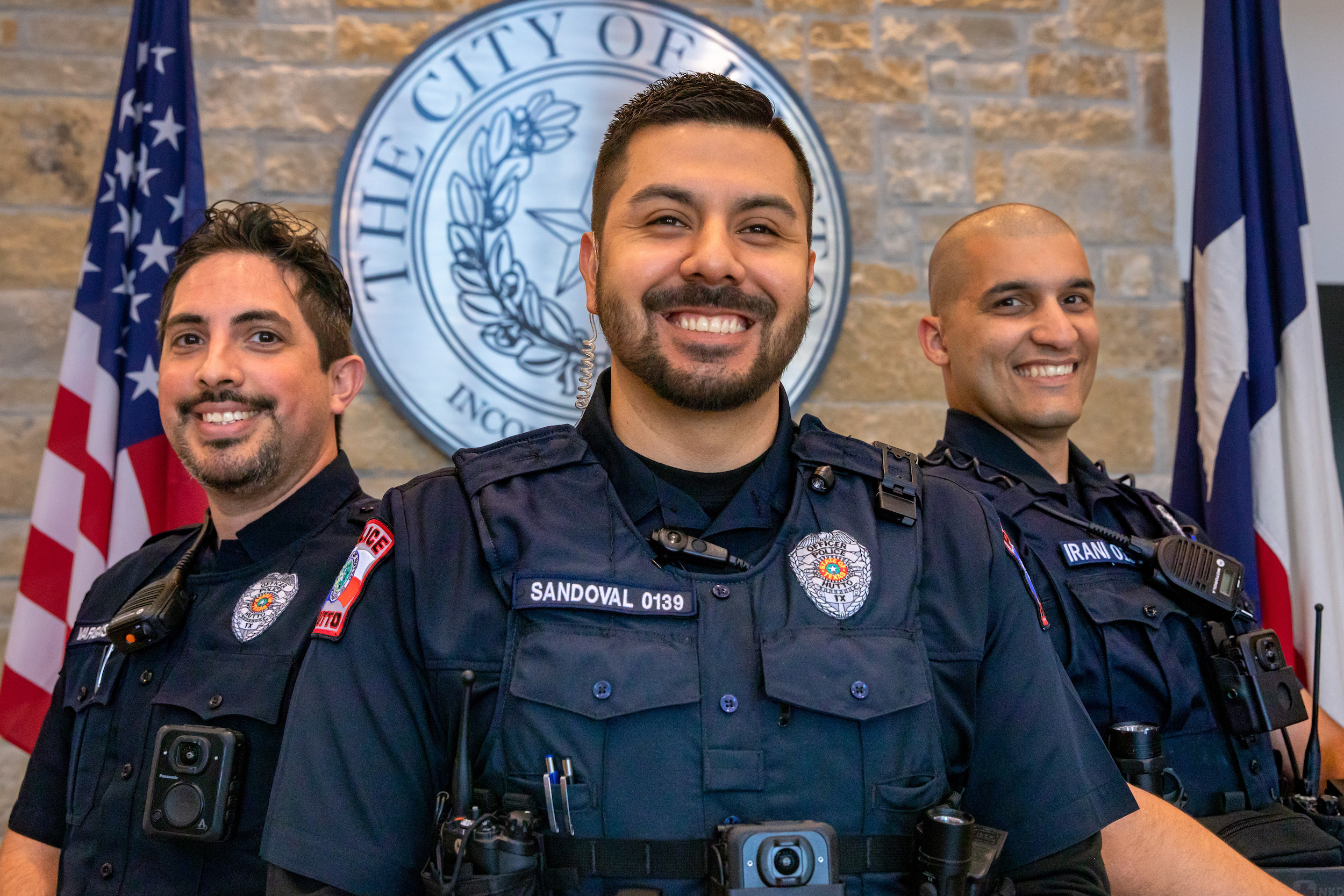 Photo of three police officers standing in front of The City of Hutto seal